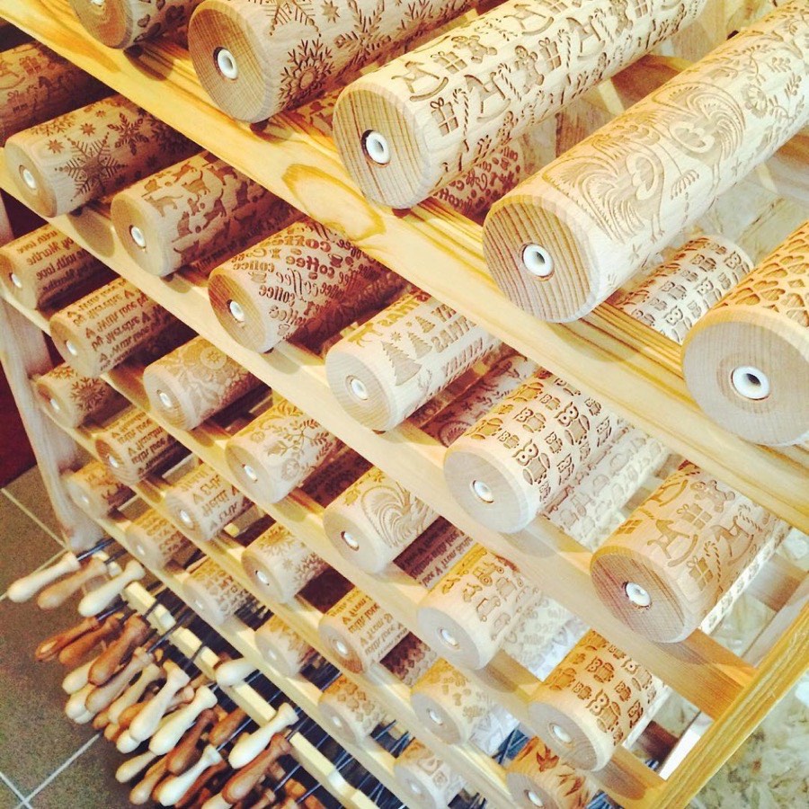 Freshly engraved rolling pins drying on a wooden rack in 2015