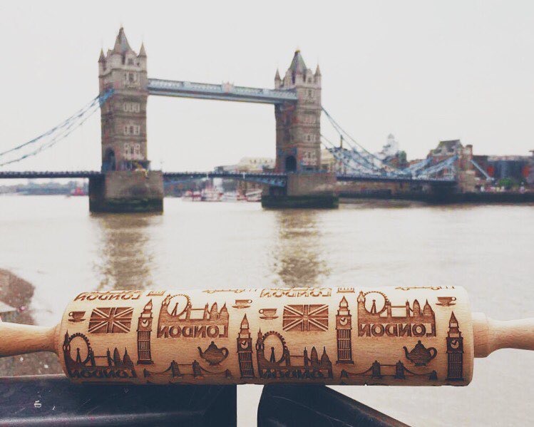 A London rolling pin engraved with Big Ben and British flags, in front of Tower Bridge